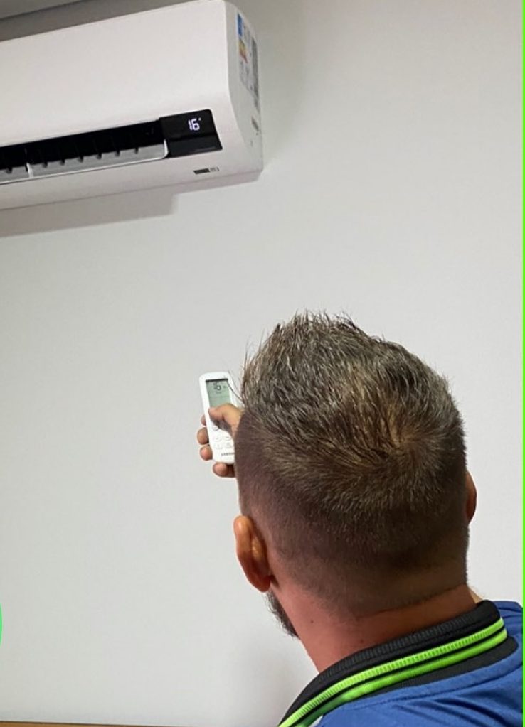 Técnico testando o aparelho com o controle remoto